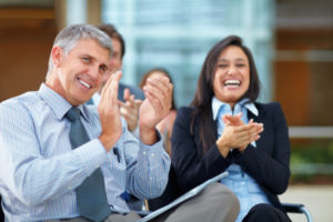 People clapping and smiling at a better than average presentation